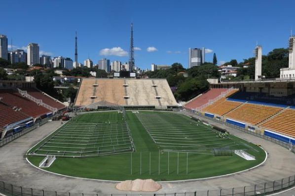 3月23日，建筑工人在巴西圣保罗市的帕卡恩布体育场内建造“方舱医院”。